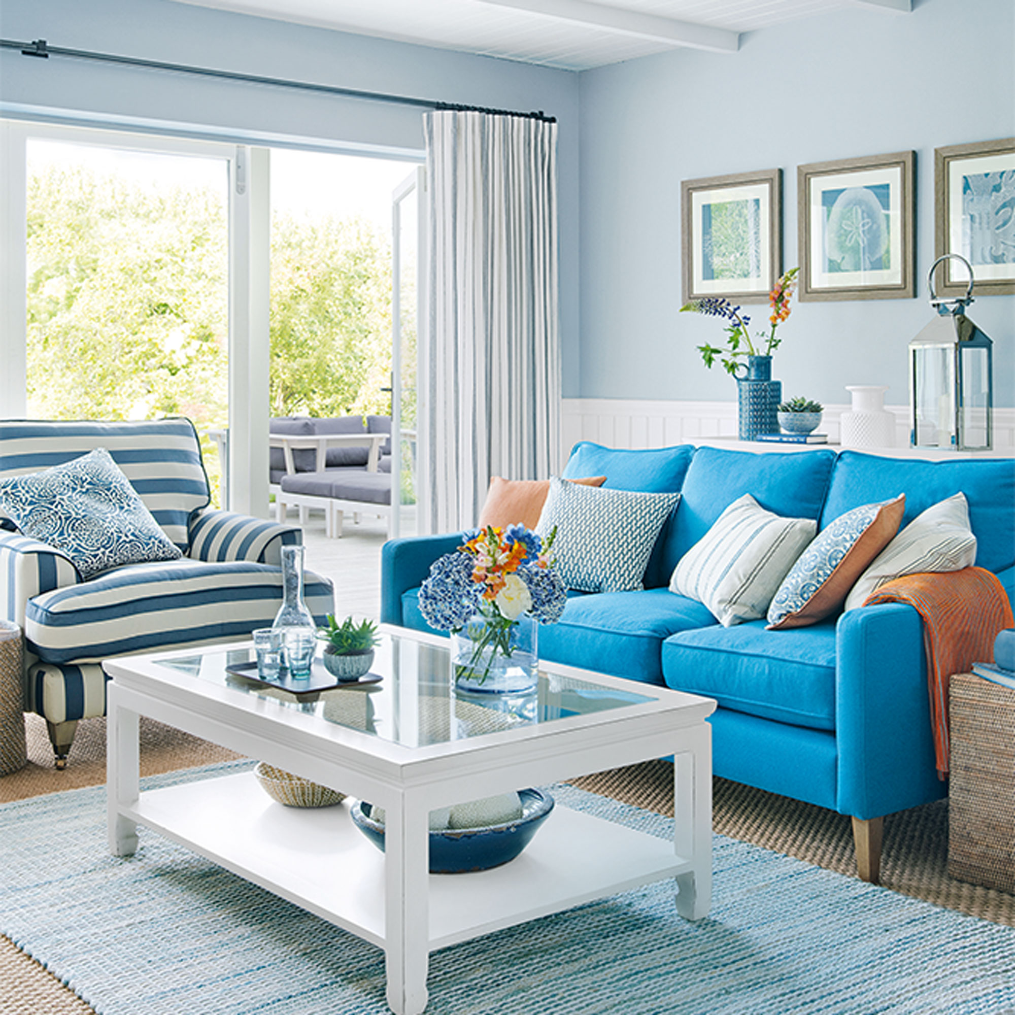 ruang tamu biru muda dengan langit-langit putih dan tirai bergaris dan sofa pirus