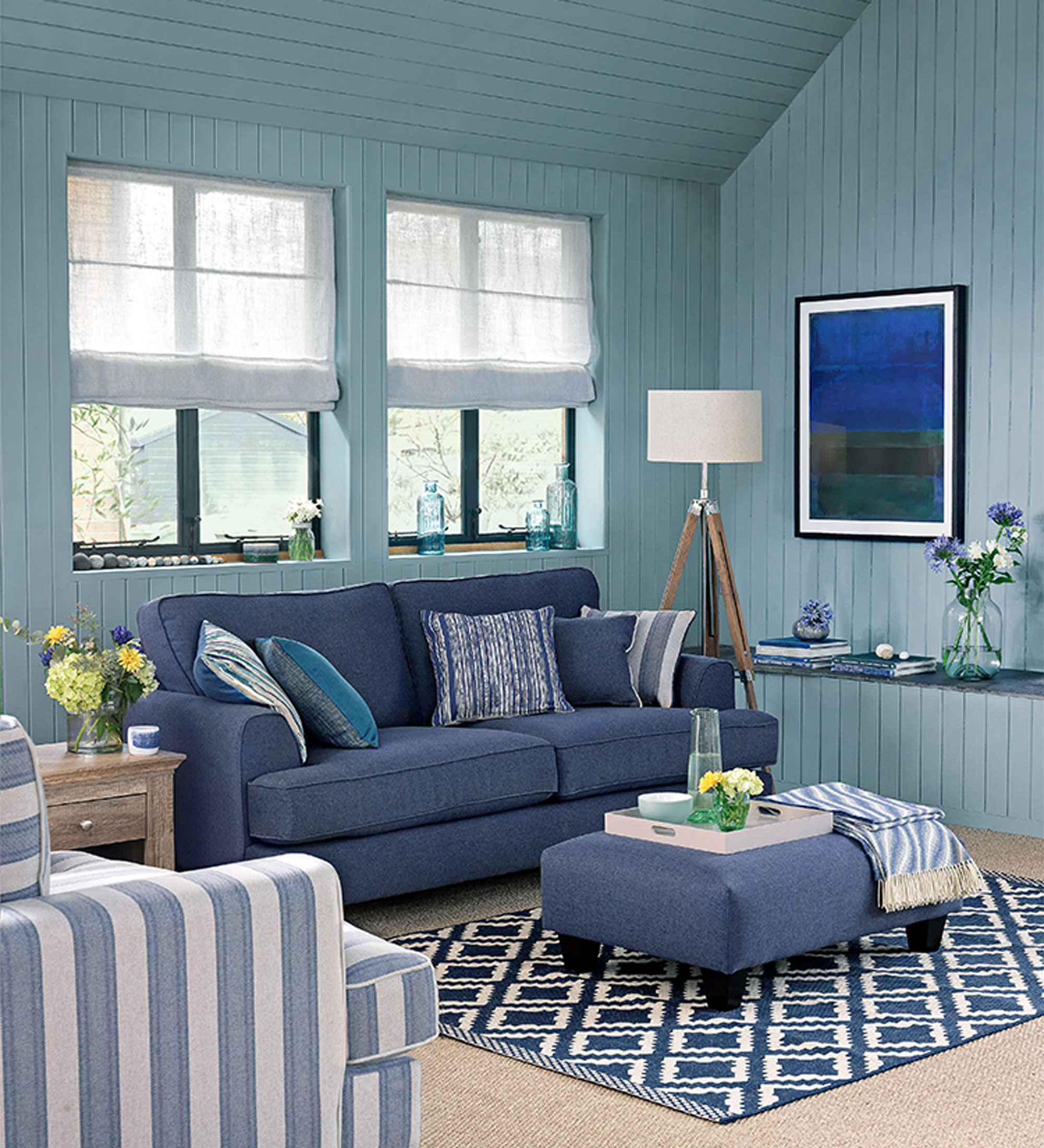 ruang tamu panel biru dengan langit-langit ke kip dan sofa biru