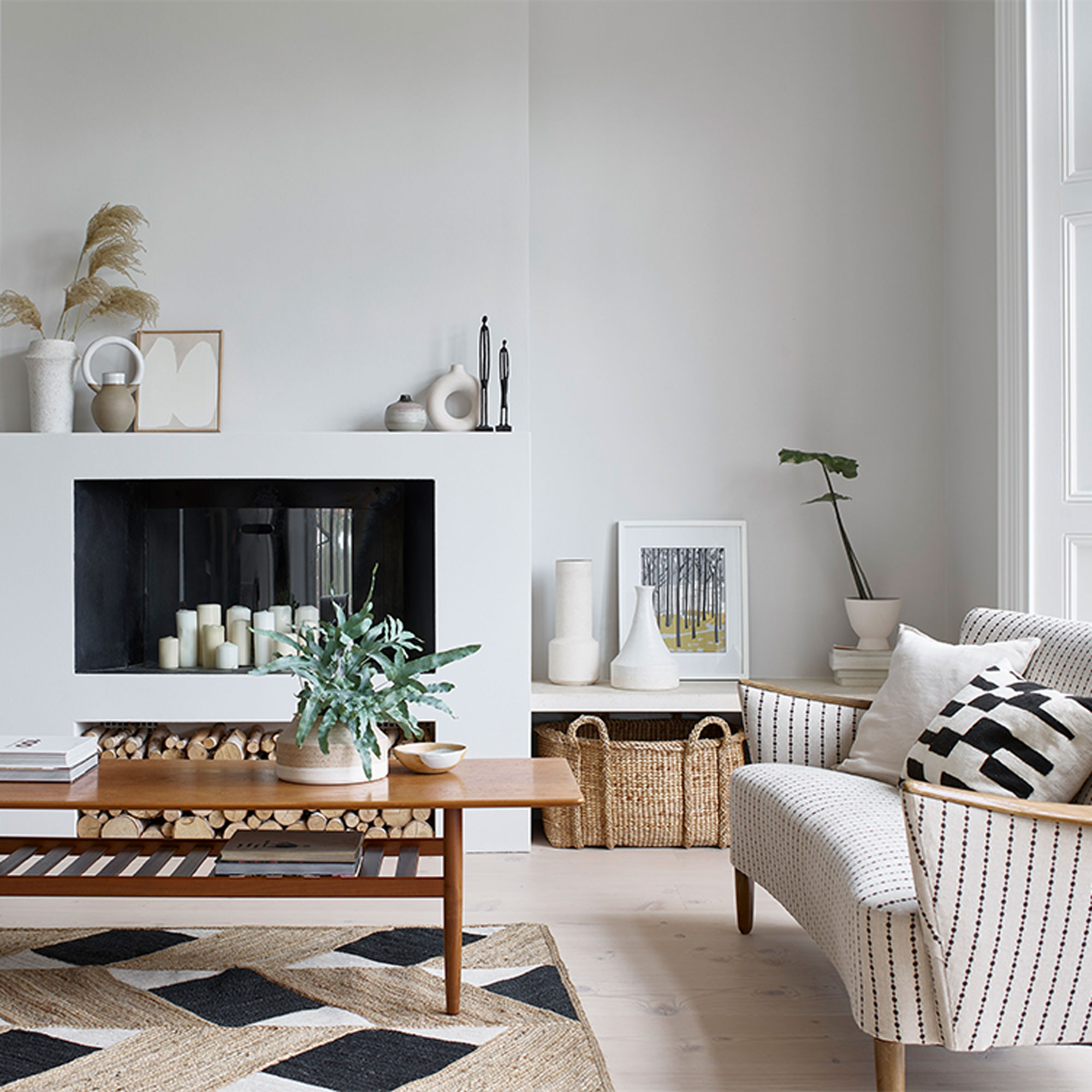 ruang tamu putih dengan meja kopi kayu perapian modern dan sofa putih dan hitam