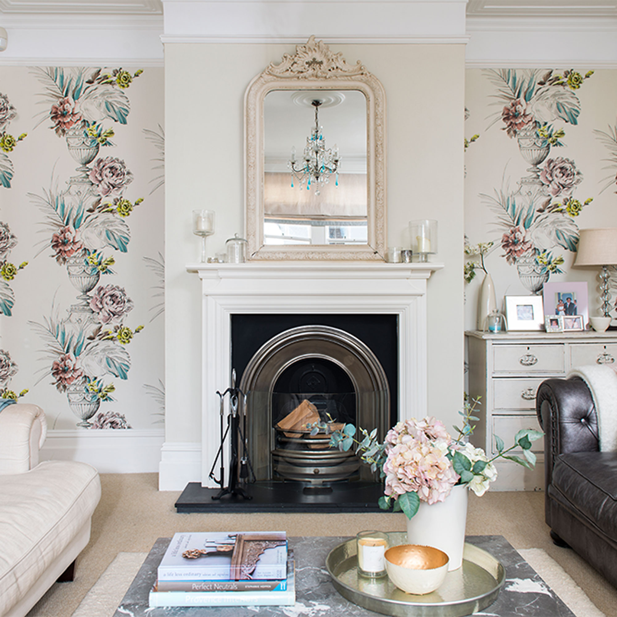 ruang tamu netral dengan wallpaper bunga di ceruk dan cermin perapian
