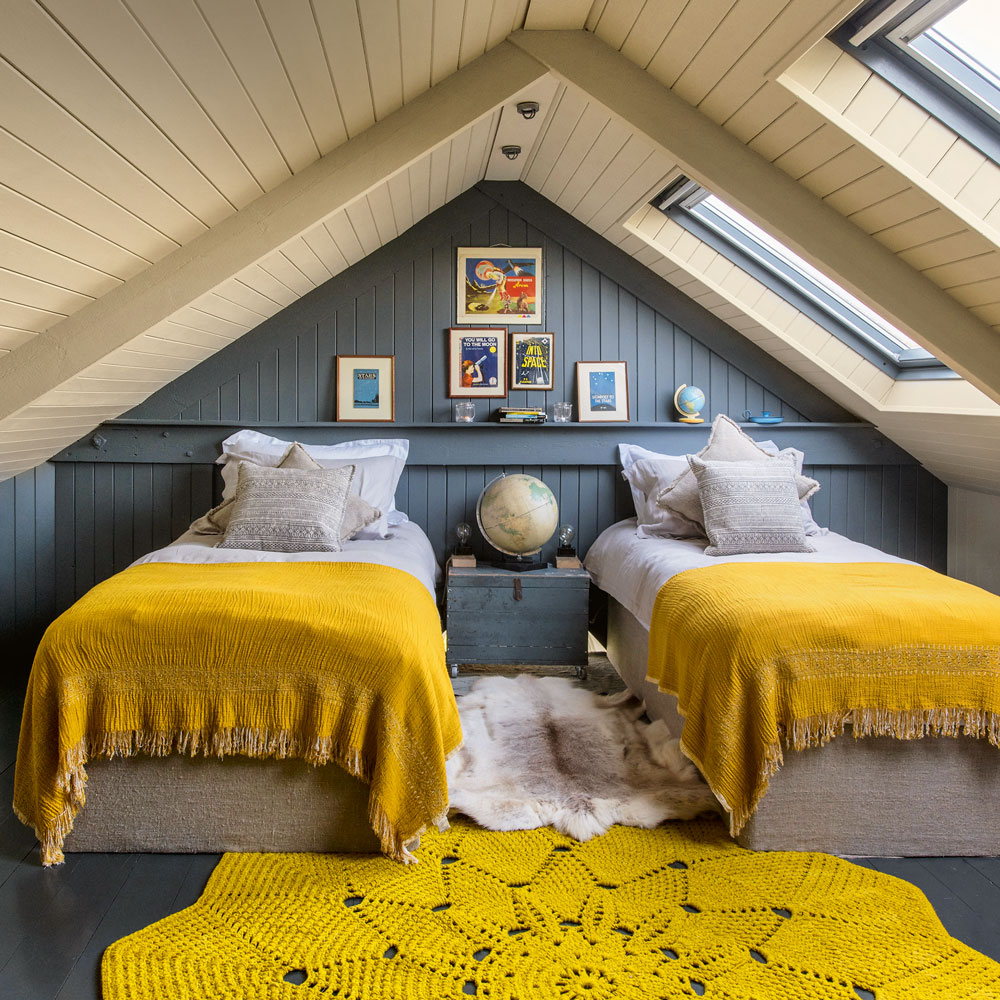 kamar tidur loteng dengan dua tempat tidur abu-abu dengan dinding dan karpet mustard