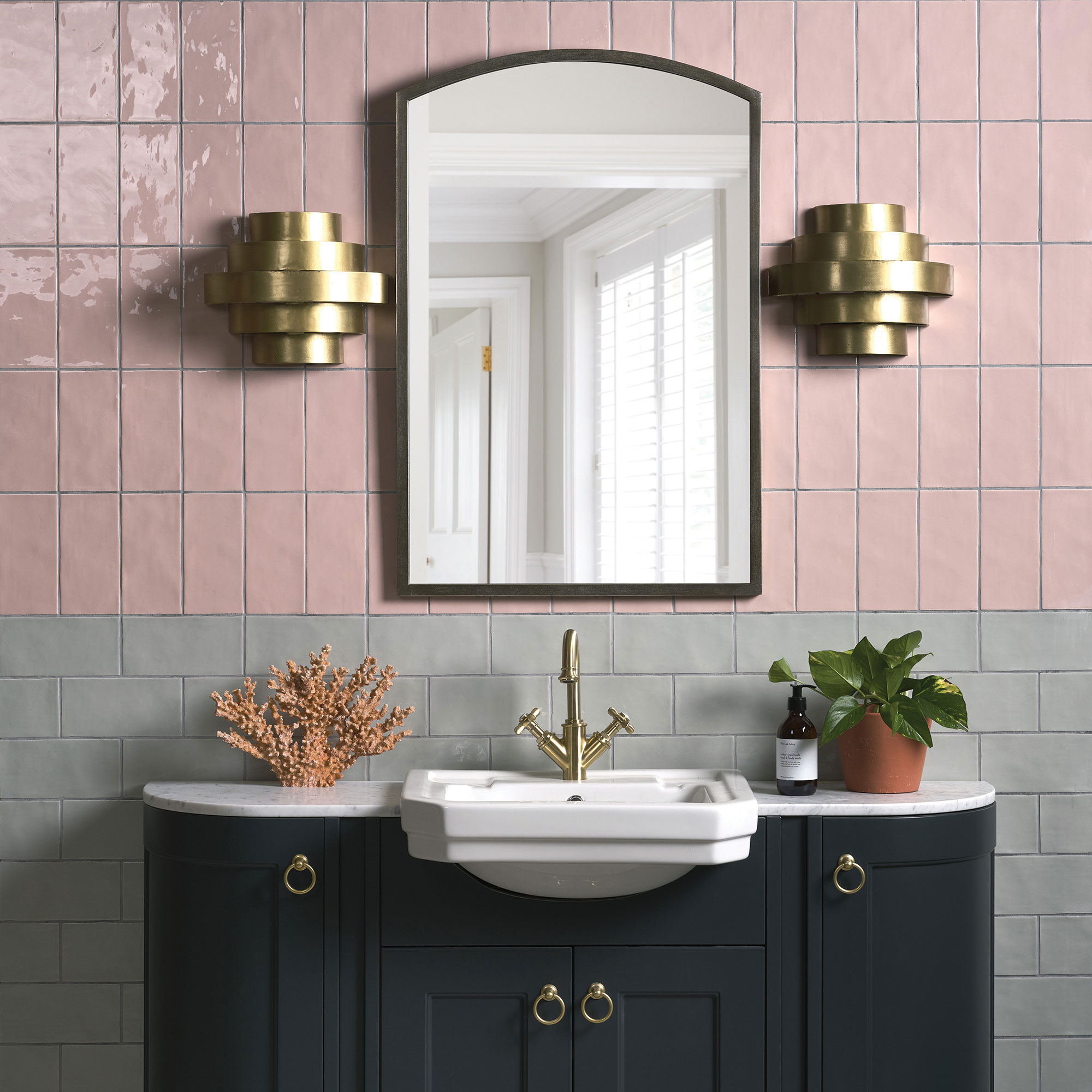 Kamar mandi dengan ubin dinding berwarna merah muda dan abu-abu, meja rias dan cermin