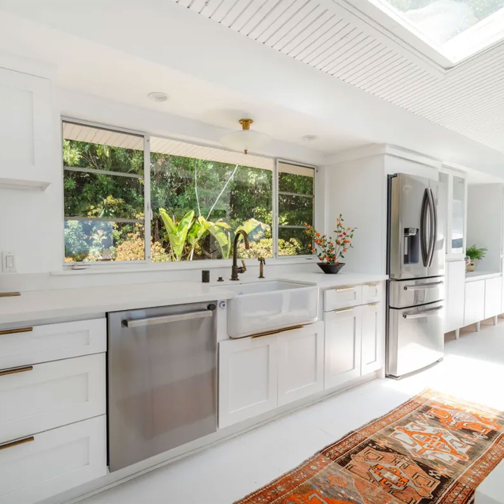 dapur dapur putih panjang dengan peralatan stainless steel dan karpet antik di lantai