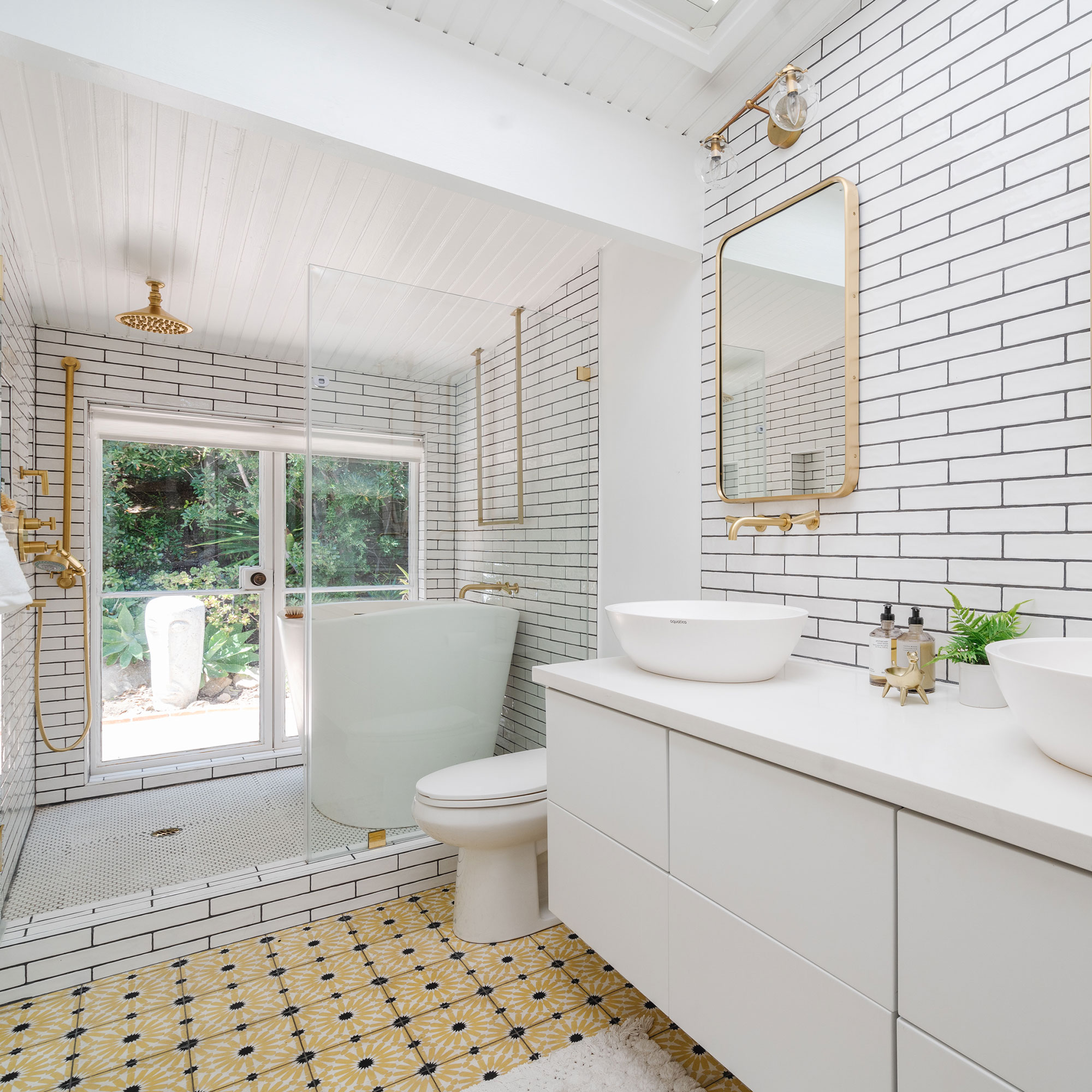 kamar mandi putih dengan perlengkapan emas dan ubin lantai berpola