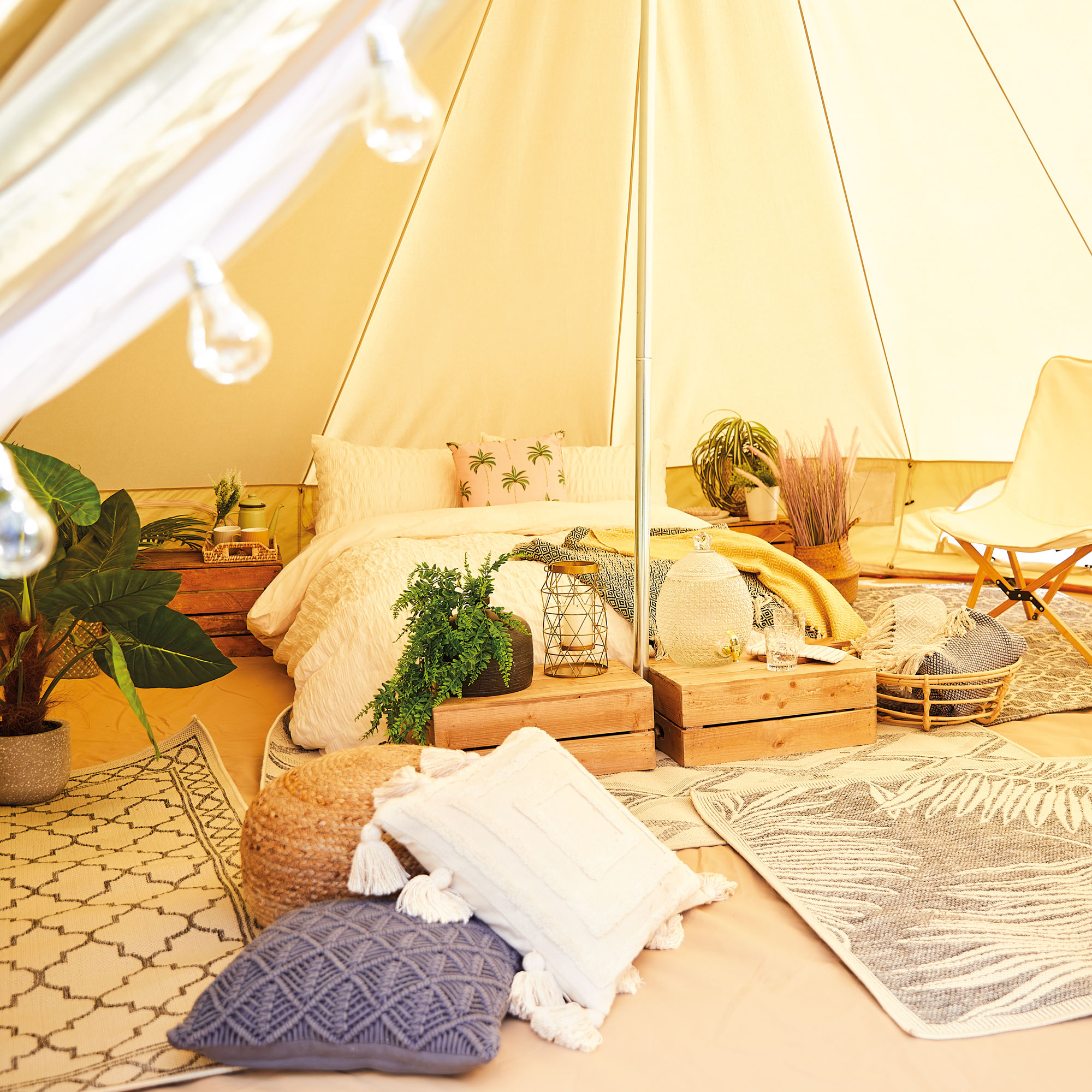 interior tenda lonceng aldi dengan tempat tidur, bantal, dan selimut luar ruangan